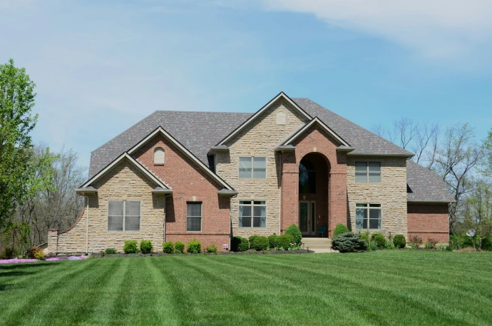 a large brick house with grass in front of it